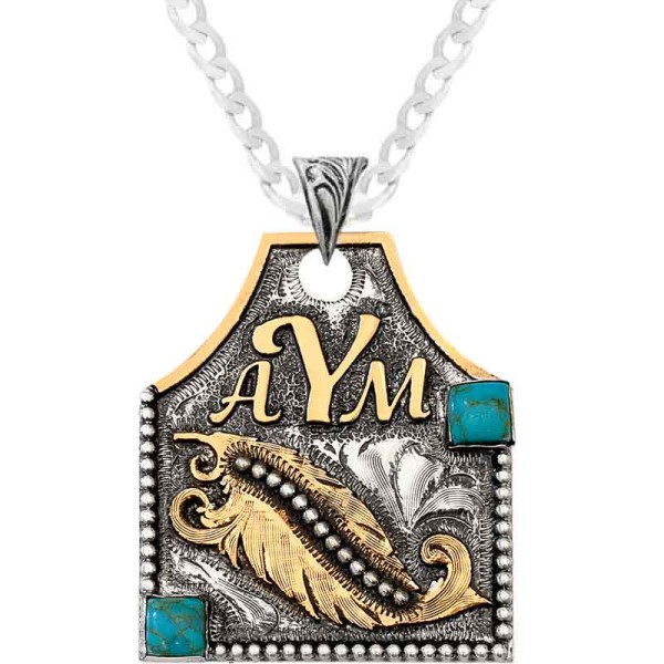 A cow tag necklace featuring custom bronze lettering, feather figure and turquoise stone 